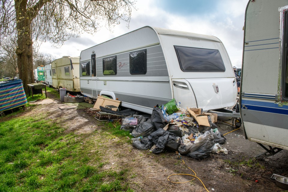 Some caravans are padlocked and have large piles of bin bags piled up nearby