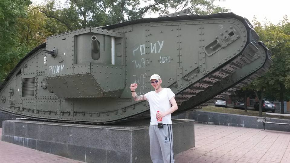 A younger Stimson posing up next to a tank