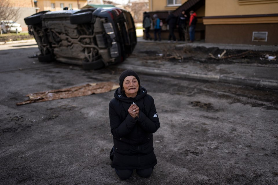 A woman cries after the deaths of family members in Bucha