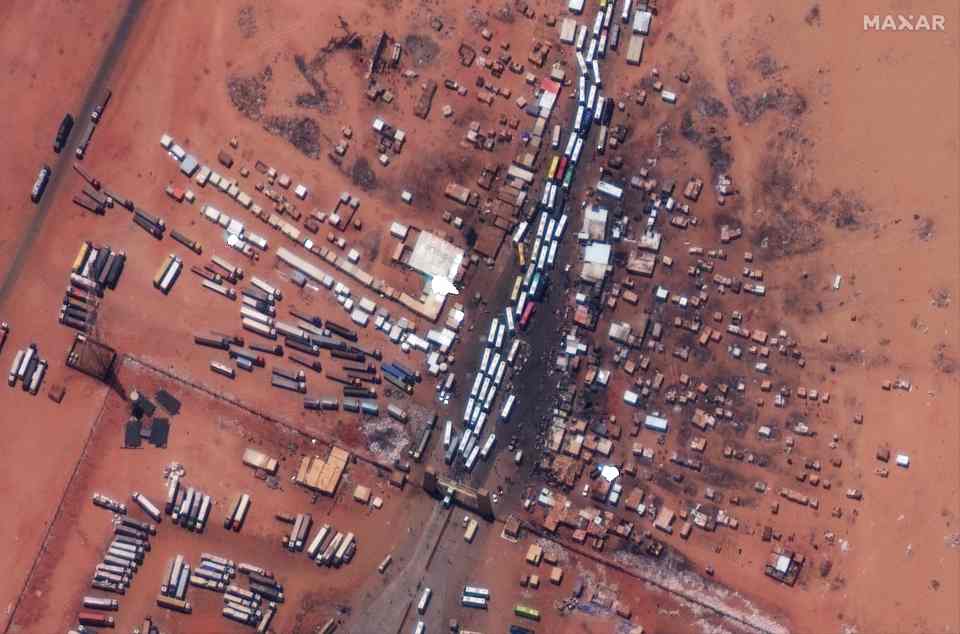 Buses wait in line at the Sudanese border of Argeen with Egypt to evacuate people into Egypt