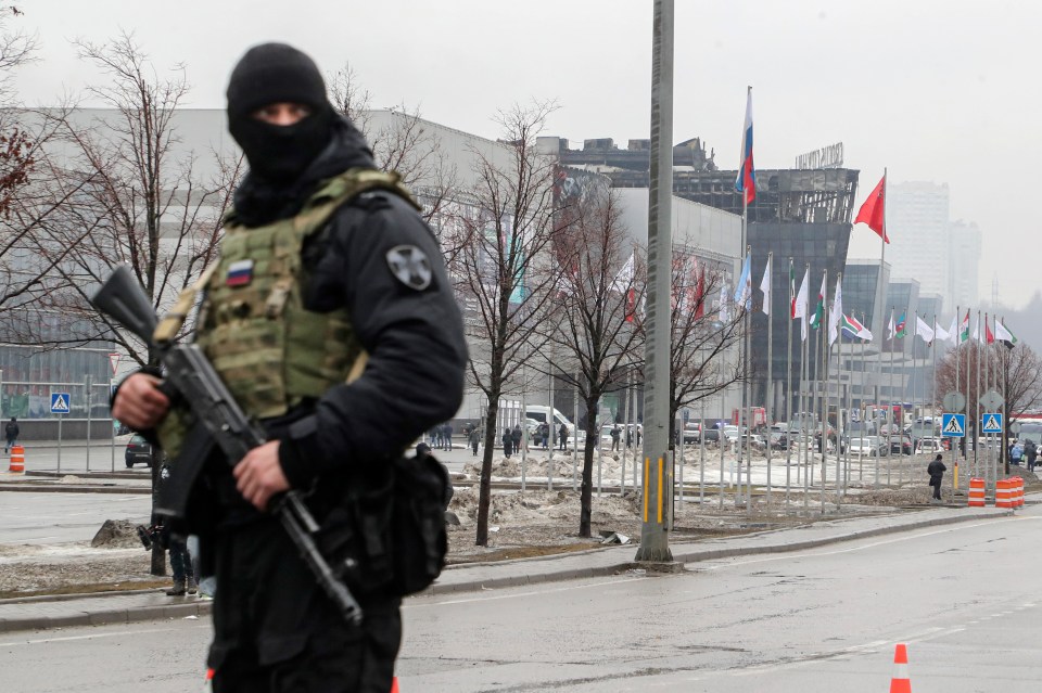 A Russian policeman guards near the burned Crocus City Hall concert venue