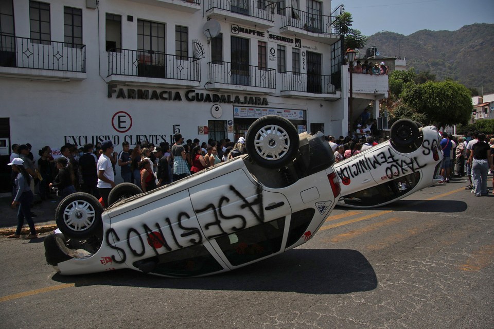 The violent protesters overturned police cars and blocked the road