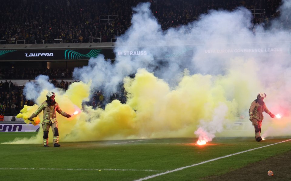 The away end continued to throw flares on to the pitch while firefighters removed them