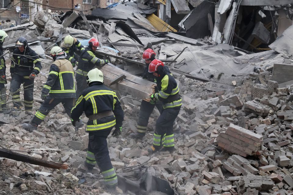 Rescue workers pulling out people through rubble