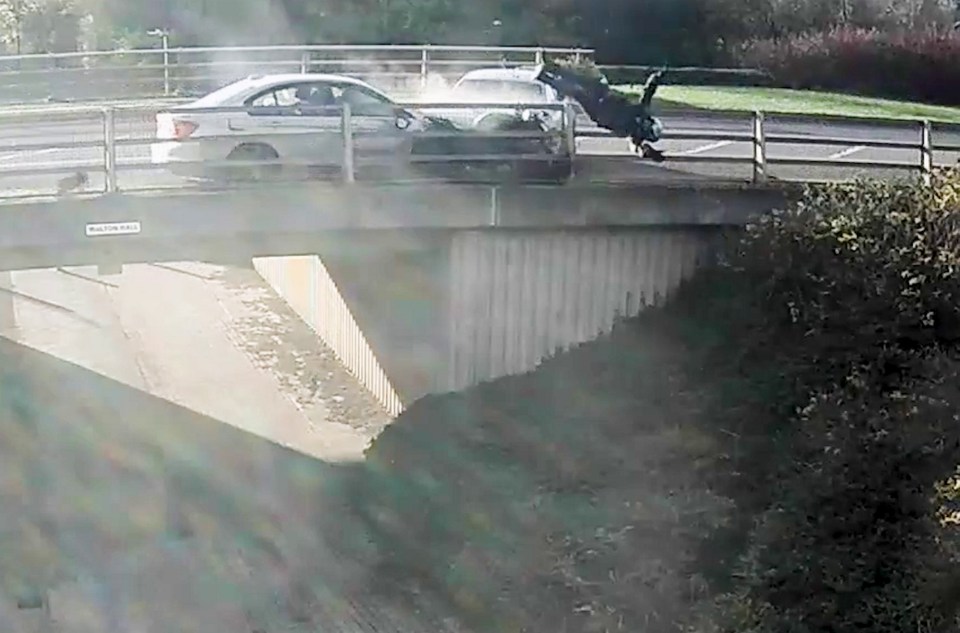 The shocking video shows the motorist catapulted over the bridge