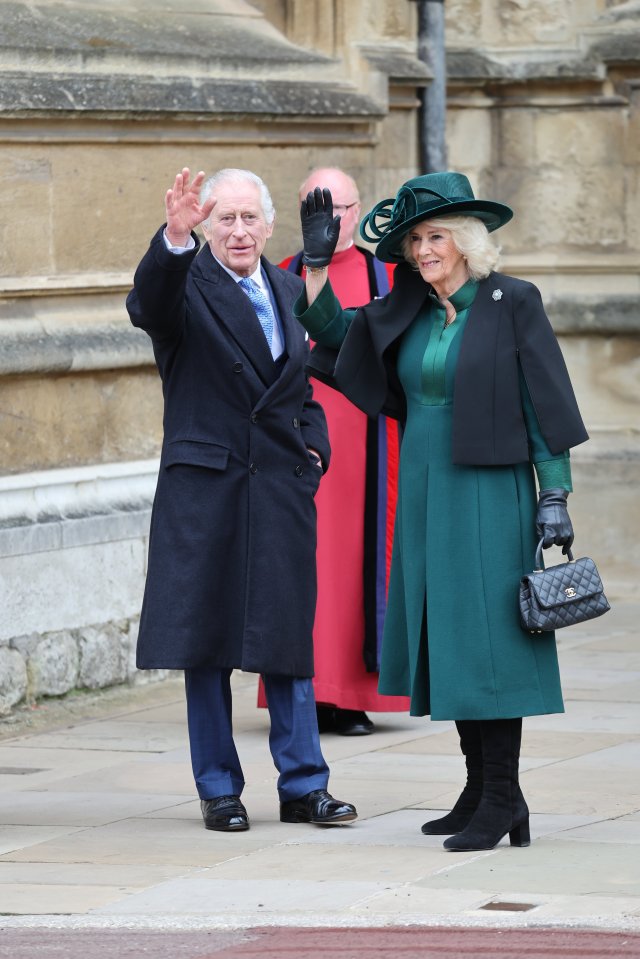 The King, wearing a dark coat and blue tie, smiled and waved at members of the public