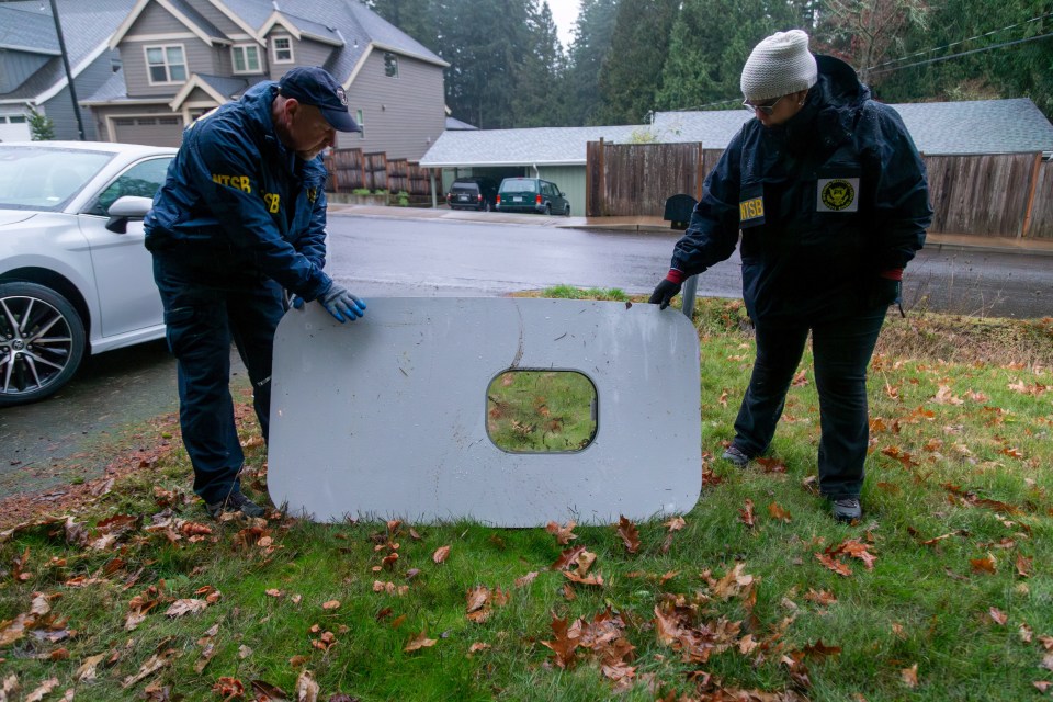 Investigators examine the fallen window from the Alaska Airlines plane