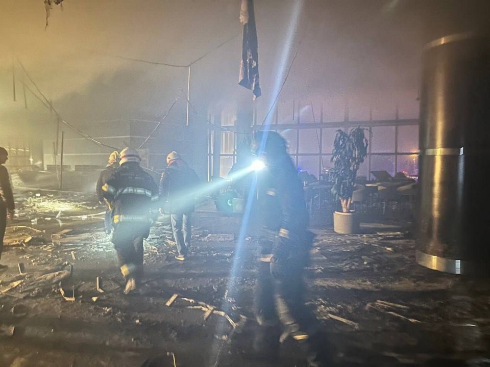 Rescuers search through the burnt wreckage to find more survivors