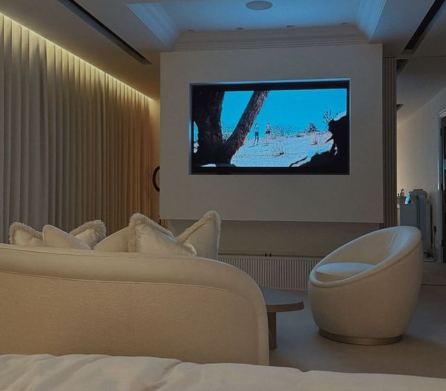 a living room with a large flat screen tv on the wall