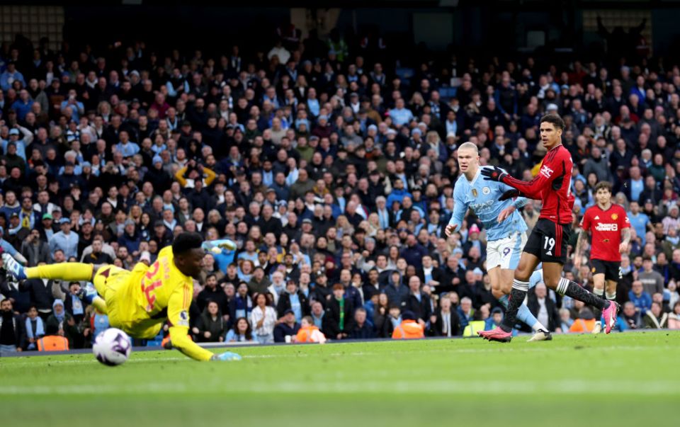 MANCHESTER, ENGLAND - MARCH 03: Erling Haaland of Manchester City scores his team's third goal past Andre Onana of Manchester United during the Premier League match between Manchester City and Manchester United at Etihad Stadium on March 03, 2024 in Manchester, England. (Photo by Catherine Ivill/Getty Images)