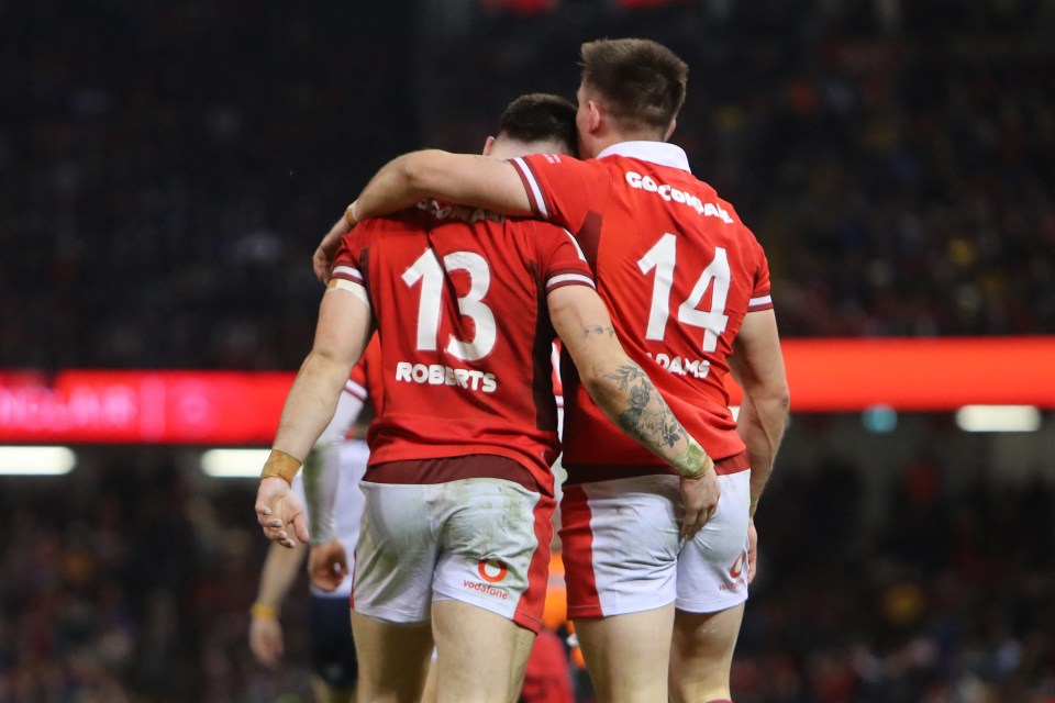 Wales' centre Joe Roberts (L) is congratulated by Wales' wing Josh Adams