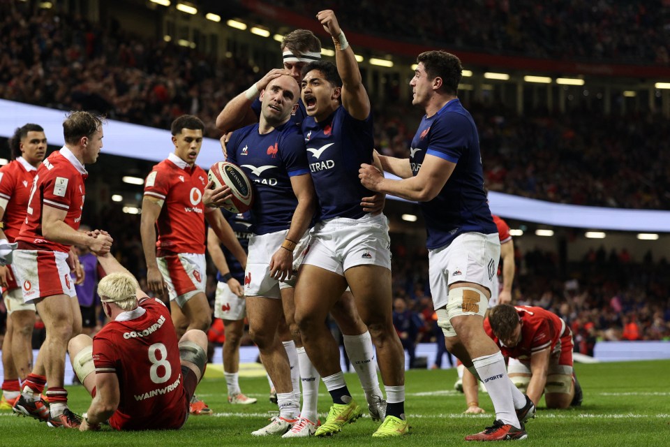 France's Maxime Lucu celebrates with teammates after scoring their fifth try