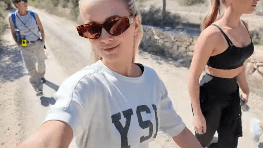 a woman wearing sunglasses and a white shirt that says ysj