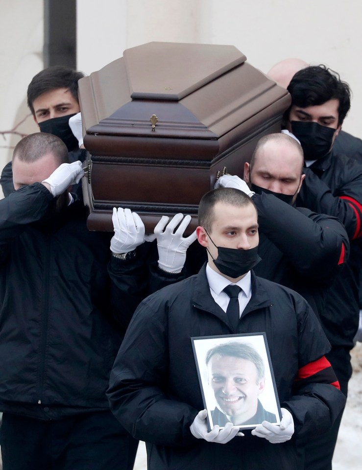 Funeral service workers carry out the coffin of late Russian opposition leader Alexei Navalny on March 1