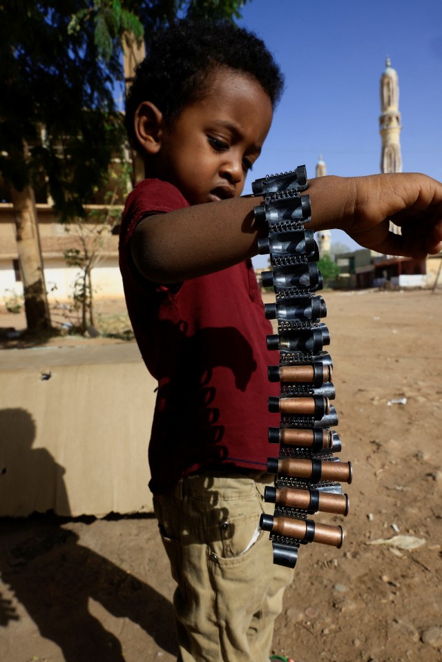 A young boy holds bullet cartridges as clashes between the RSF and Sudan's army continue in Khartoum North