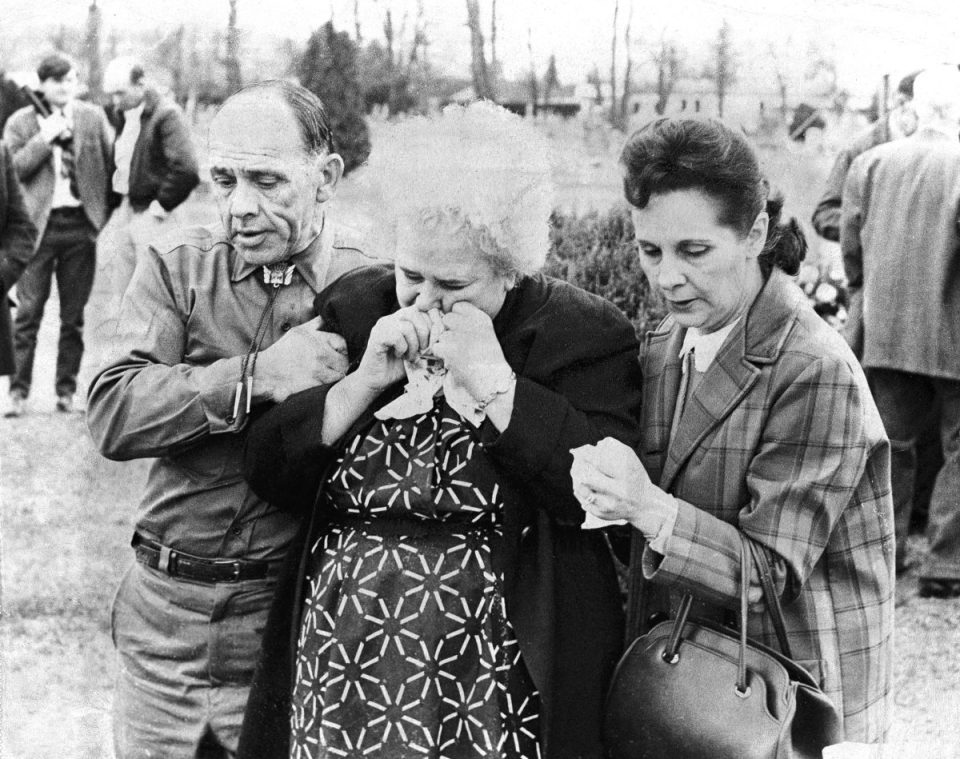 The mother of one of the victims, Melvin, weeps following her son's burial