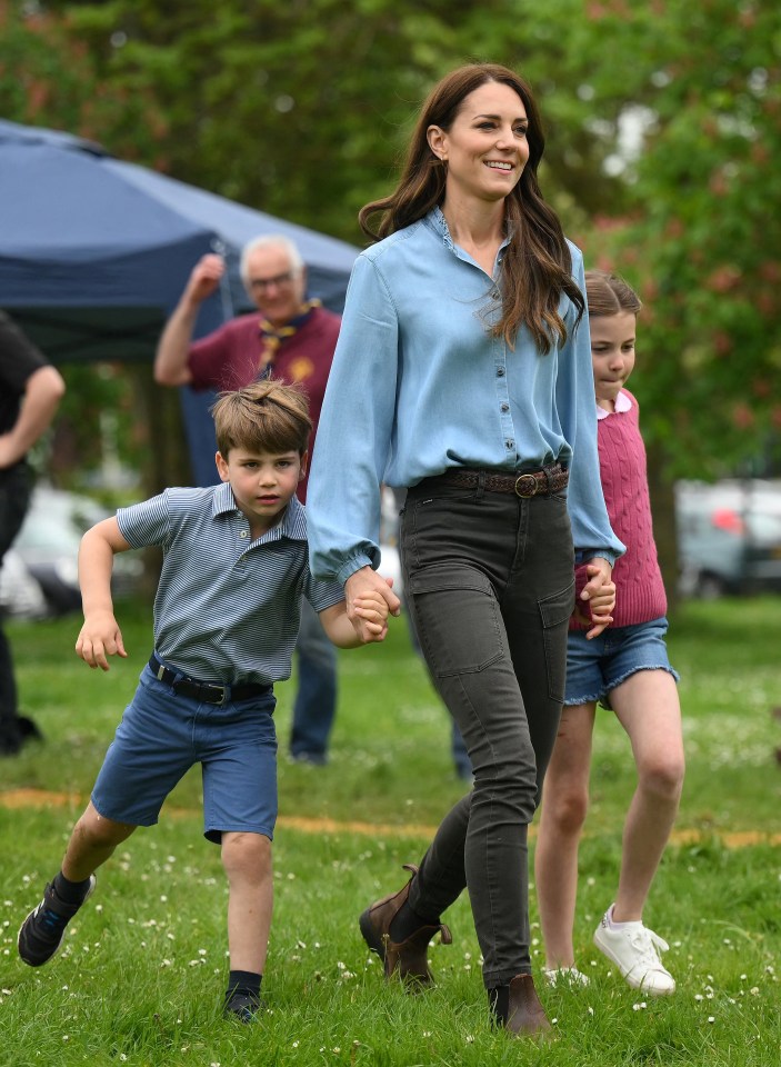 Kate – pictured here with Princess Charlotte and Prince Louis in May –  also spent Sunday morning watching her three children take part in sports