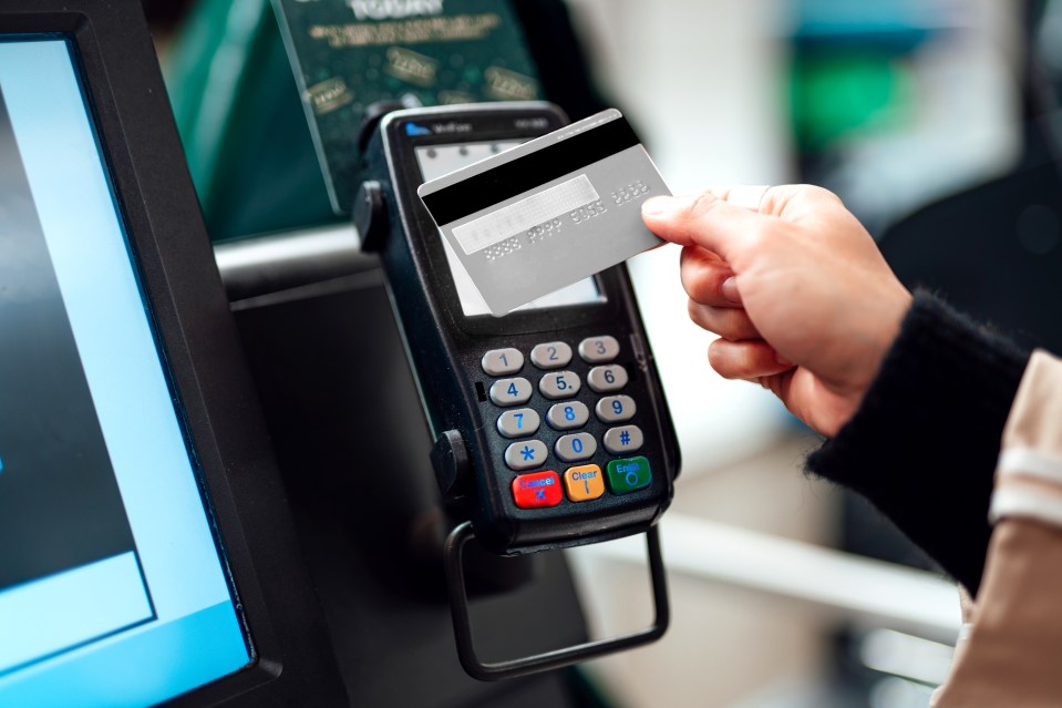 Woman using contactless payment at a self-checkout.