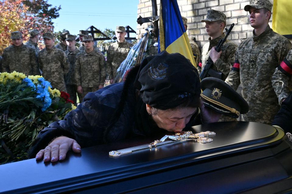 A woman cries at the grave of her loved one killed in Bucha