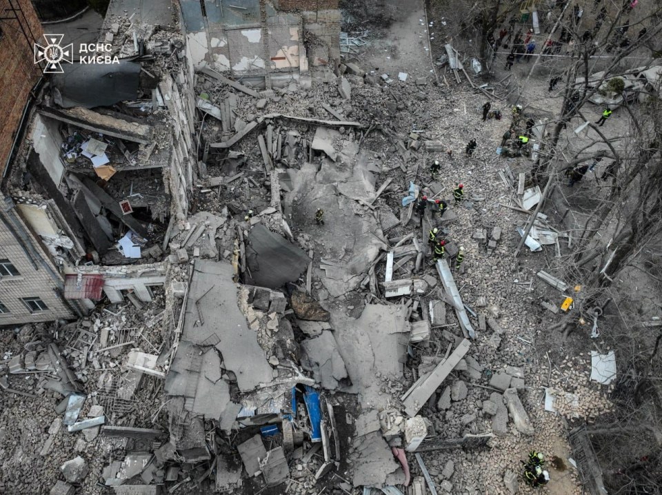 A drone view shows rescuers who work at the site of a building heavily damaged by Russian missile strike