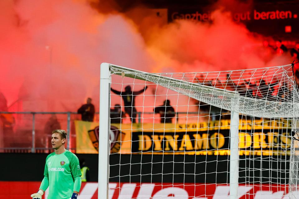 Dynamo fans set off pyrotechnics behind Dresden goalkeeper Kevin Broll