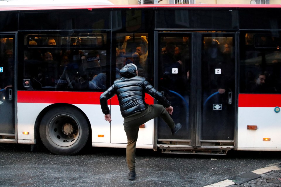 An Eintracht Frankfurt yob kicks a bus in Naples