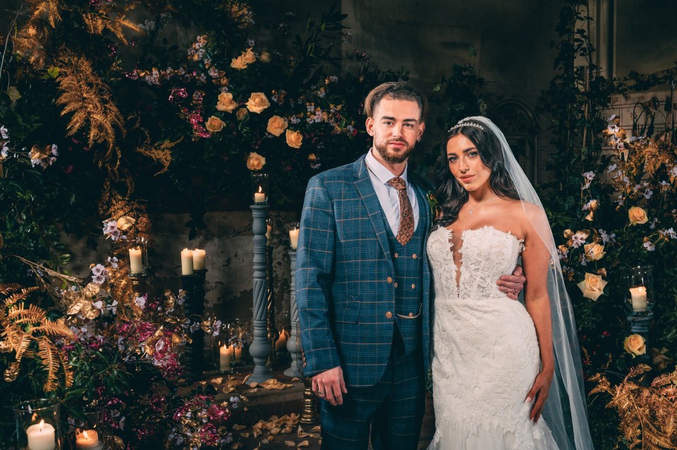 a bride and groom pose for a picture in front of flowers and candles