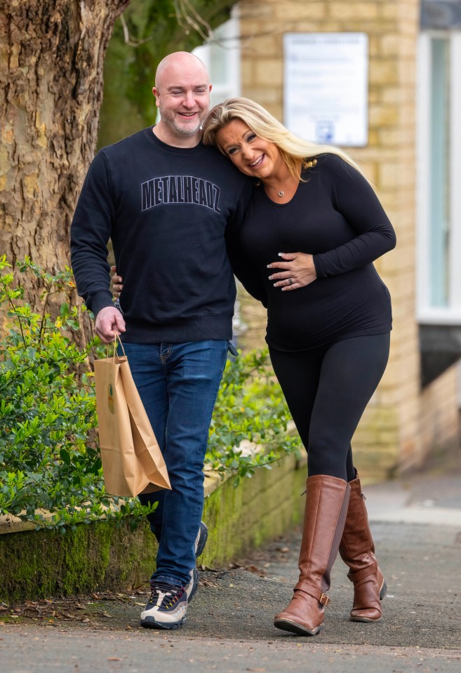 Daisy May Cooper looked blissfully happy as she cradled her baby bump on a walk with her new man