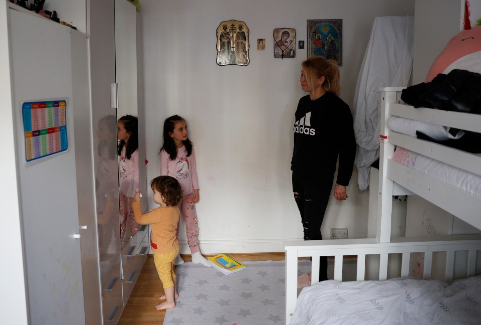 Elena shares a sofa bed with her youngest child, while her two other daughters sleep in bunkbeds in the flat's only bedroom