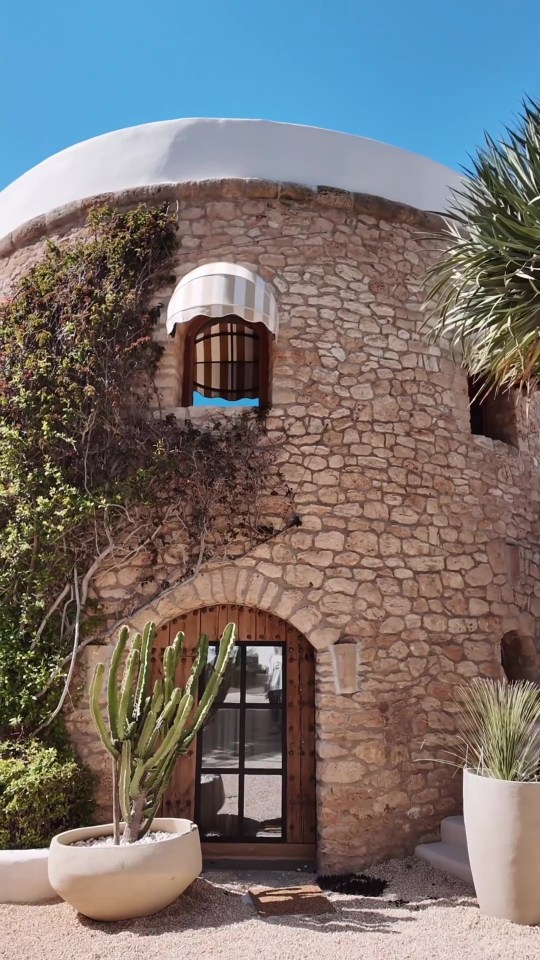 a stone building with a cactus in front of it