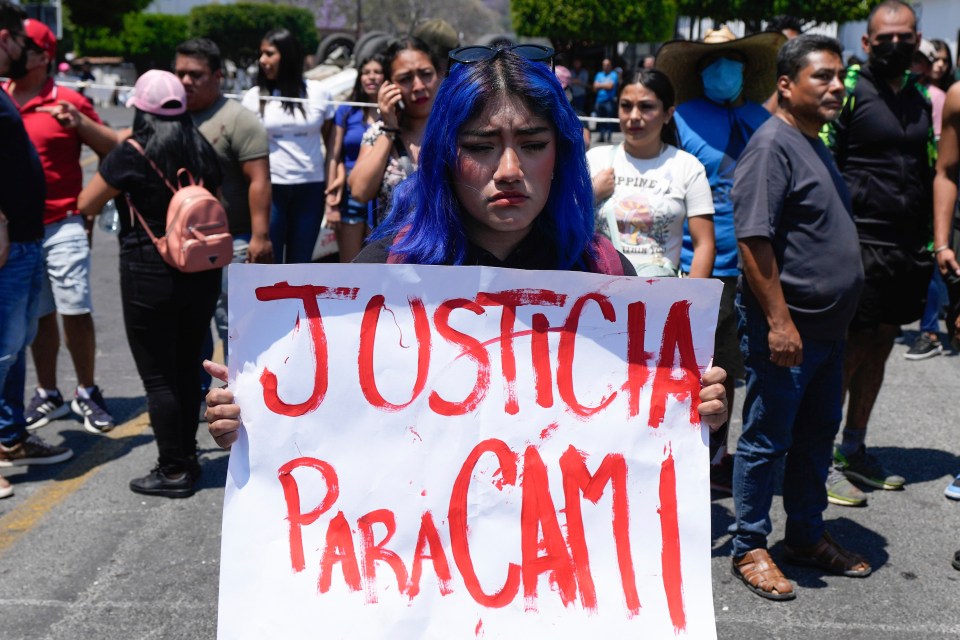 A woman holds a sign with a message that reads in Spanish: “Justice for Cami”