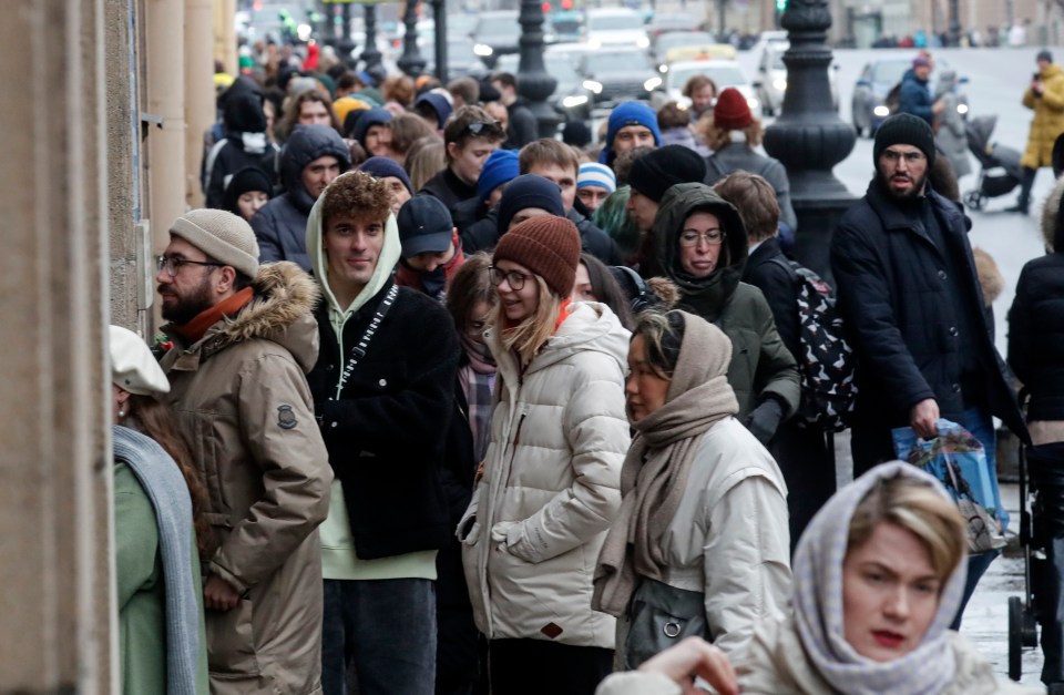 Russians stand in line outside a polling station to vote in St Petersburg today