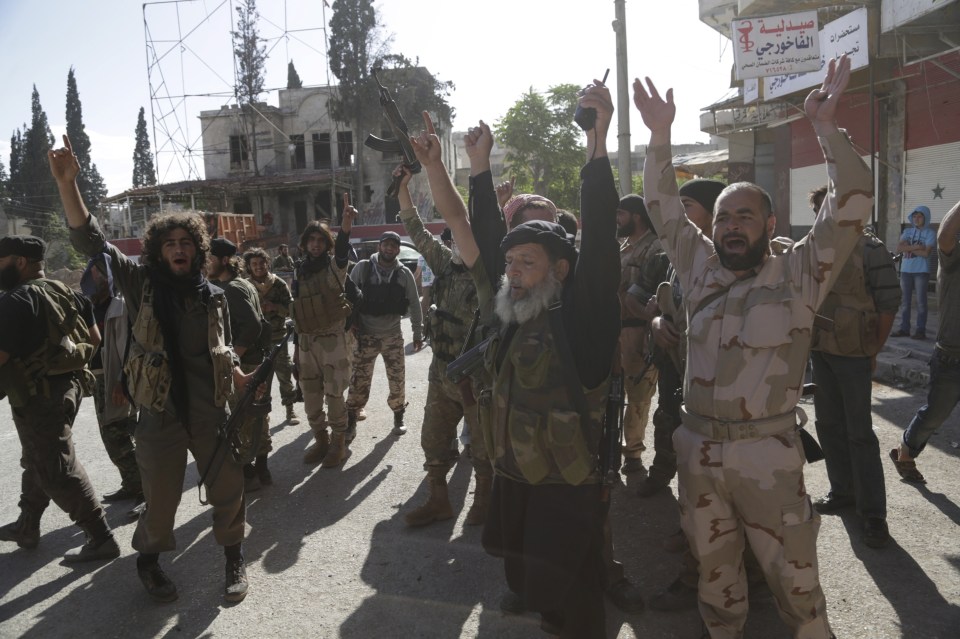 Members of al Qaeda’s Nusra Front gesture as they cheer in the northwestern city of Ariha in 2015