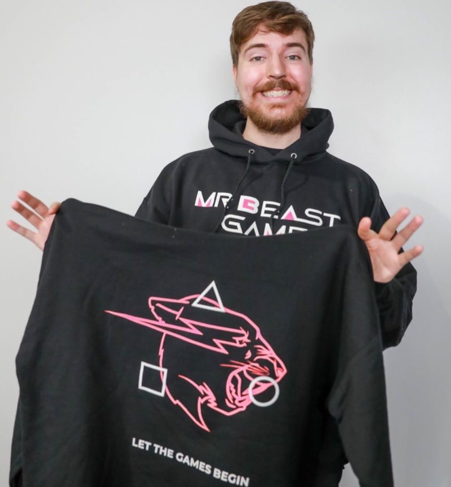 MrBeast wearing and holding hoodies branded with his new show logo