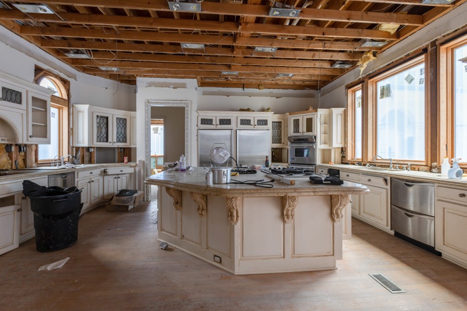 The kitchen has been left in a dire condition with insulation hanging from the ceiling and rubbish littered across the islands and floors