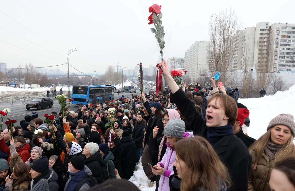 People with flowers walking to the Borisov cemetery during the funeral of Navalny