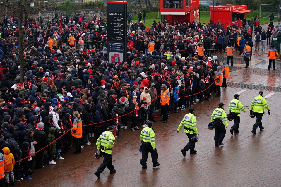 Police walk through the Liverpool fans outside the ground before the Premier League match at Anfield