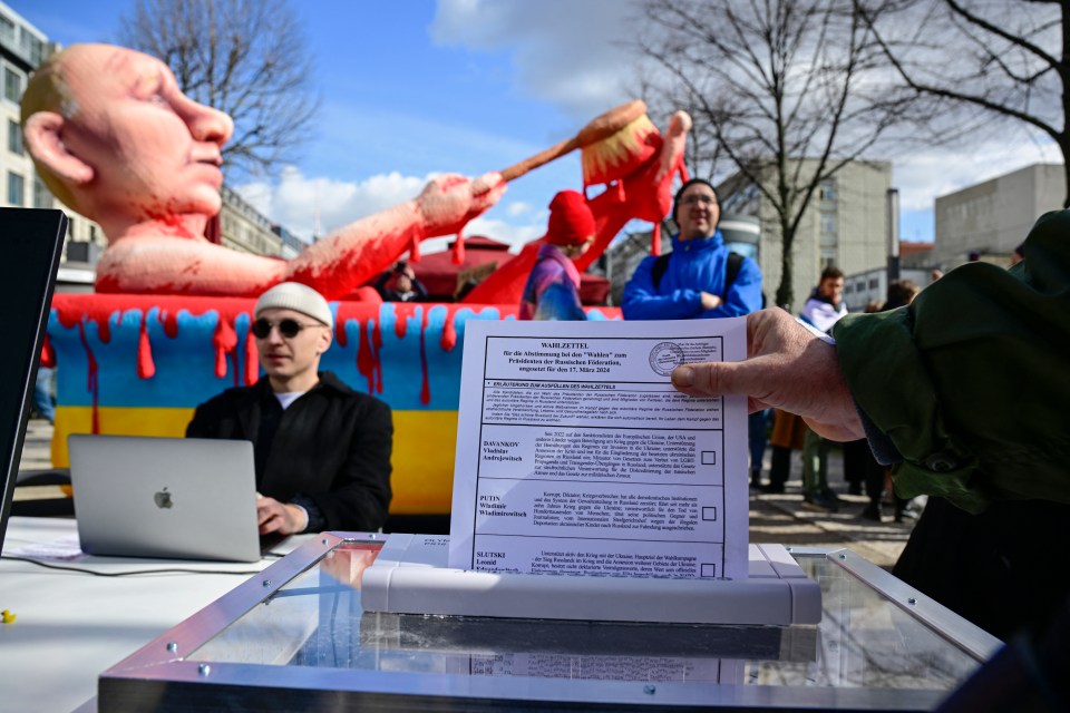 A protester feeds an ballot into a shredder machine in Berlin