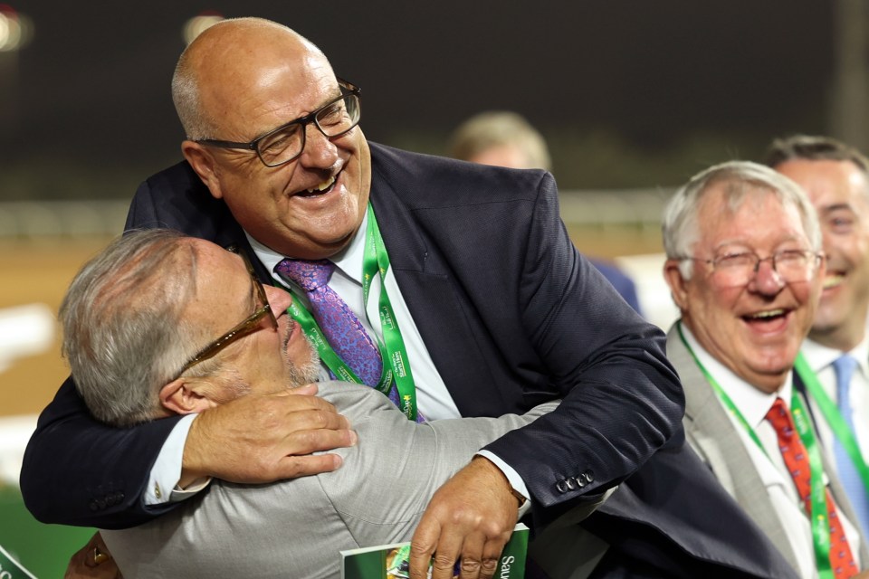 Fahey, centre, gets a big bear hug from Mason, left, as Sir Alex watches on