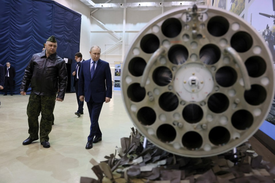 Putin taking a look at Russian military equipment alongside head of air combat and tactical training Alexander Karamyshev