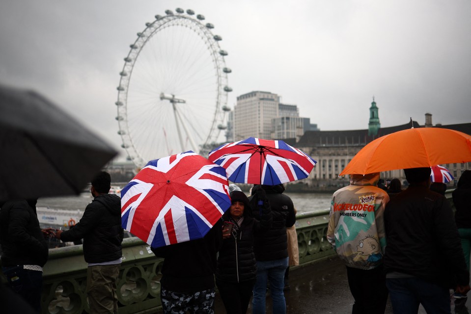 Tourists shelter from the rain beneath umbrellas in London this month as the country is soaked