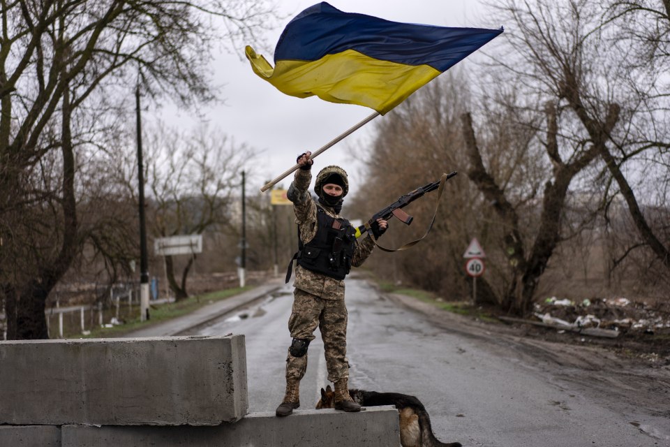 A Ukrainian soldier waves a flag following the liberation of Bucha in early April 2022