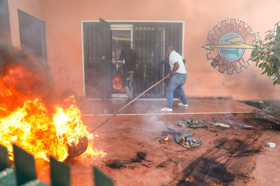 Workers put down a fire set at an office of Haiti's power company last week