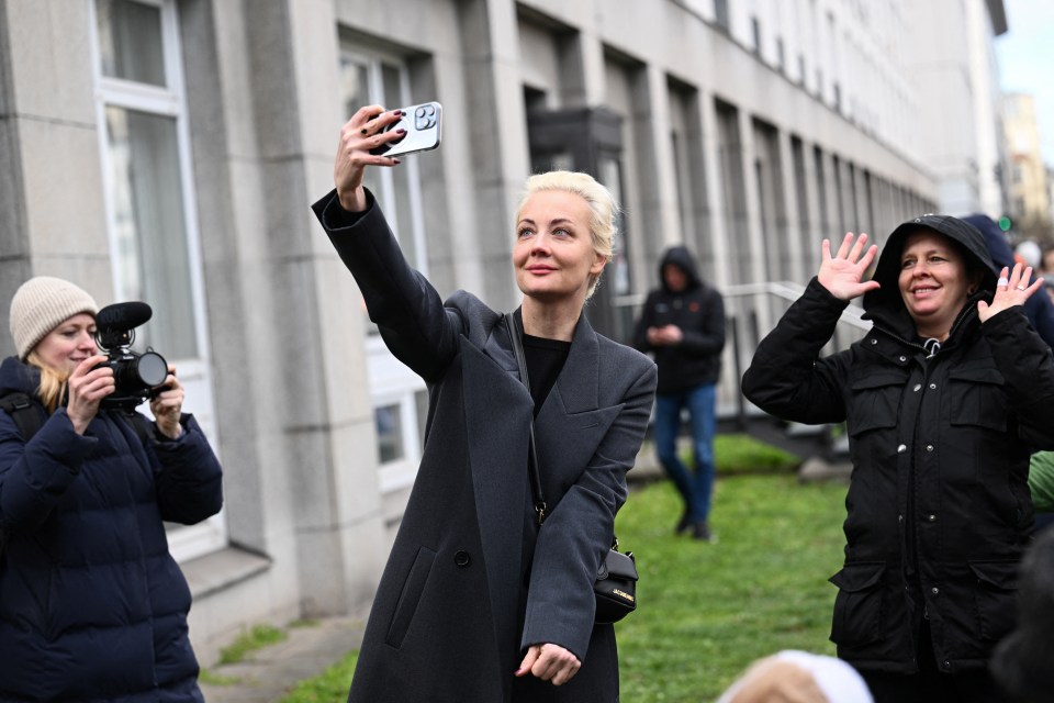 Yulia takes a selfie as she stands in a queue outside the Russian Embassy