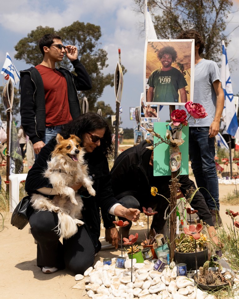 Mourners lay flowers at the makeshift memorial to one of the festival victims