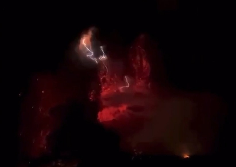 Lightning appears to strike above the volcano vent