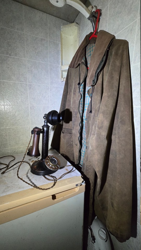 A phone sits next to a hanging jacket