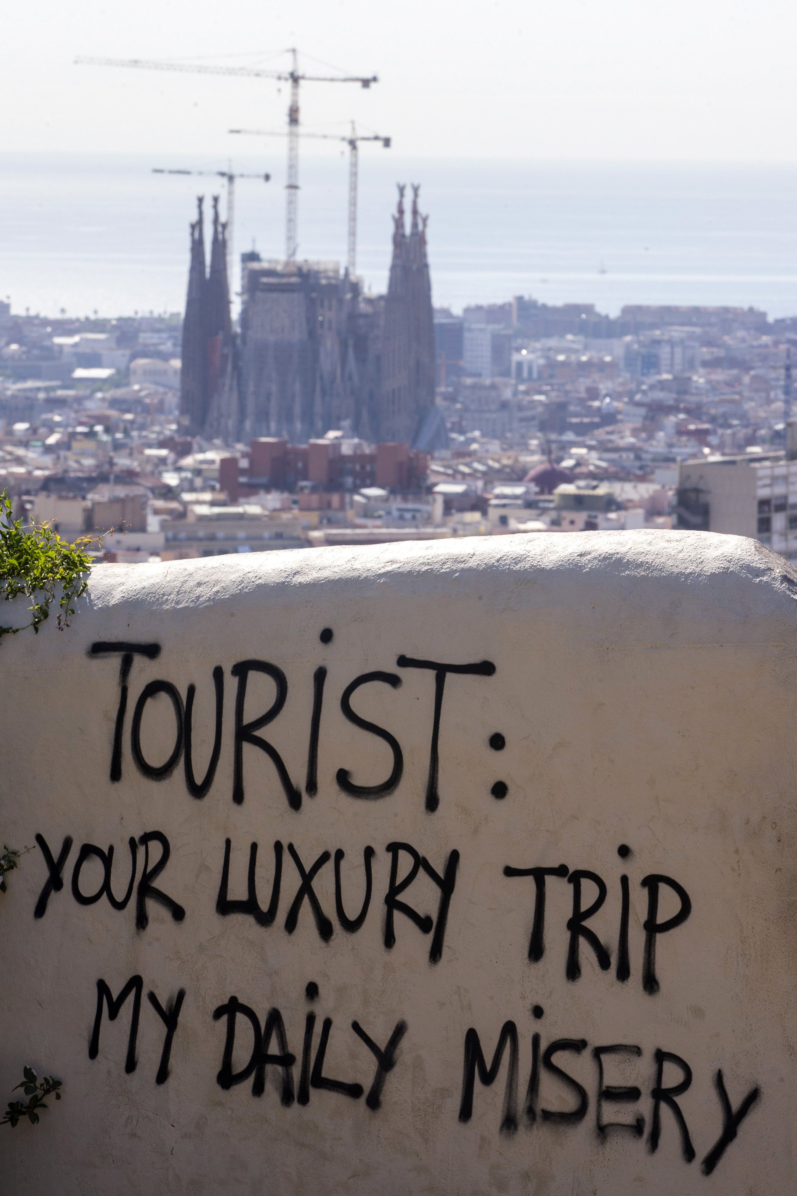 Another graffiti reads "your luxury trip, my daily misery"