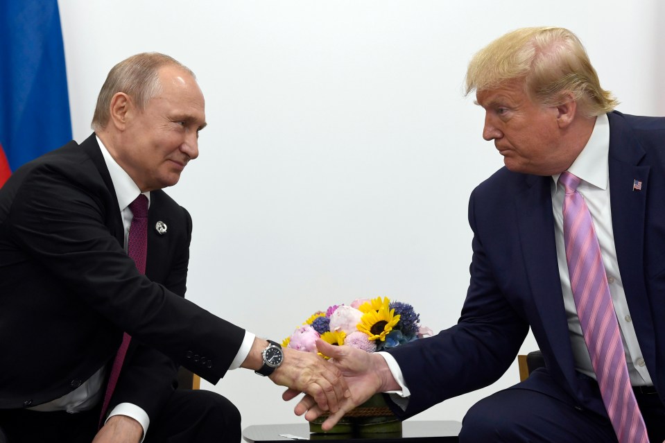 Trump shaking hands with Russian President Vladimir Putin