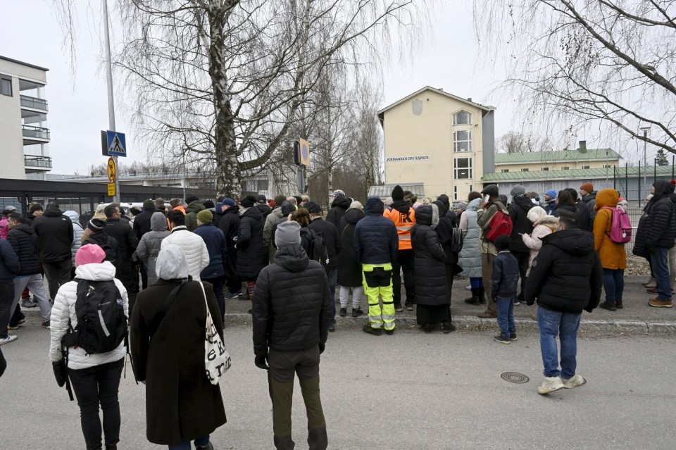 Crowds of concerned parents gather outside the school